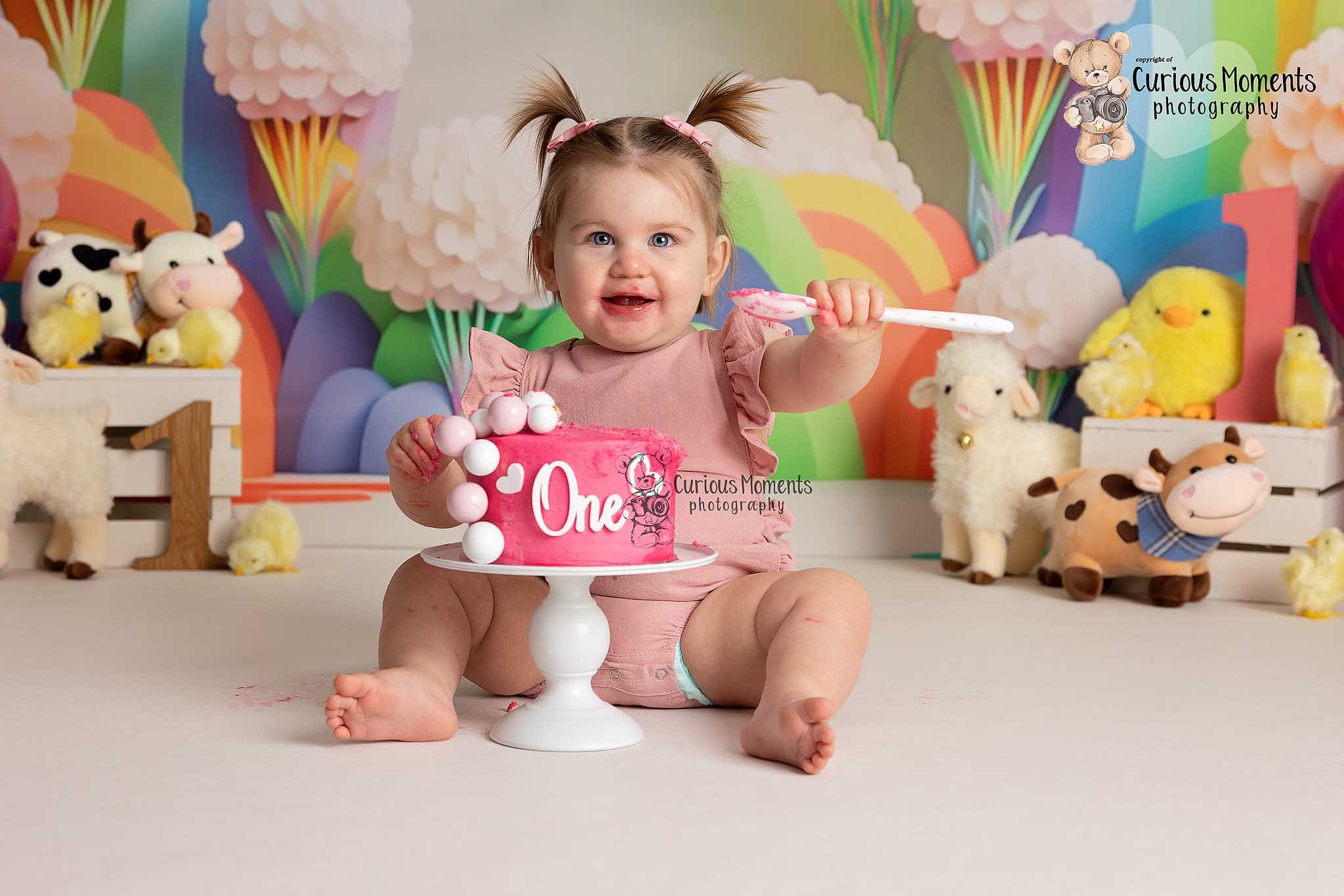 A joyful child enjoying a vibrant cake smash, captured by a professional photographer in Carmarthenshire, creating colourful and fun memories.